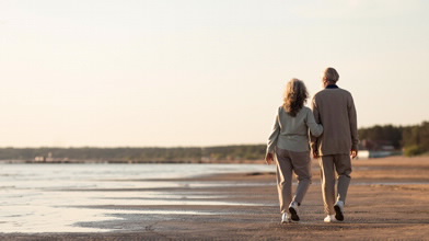 Casal a caminhar na praia e a pensar no Fundo de Pensões Aberto BPI Acções da BPI Vida e Pensões.