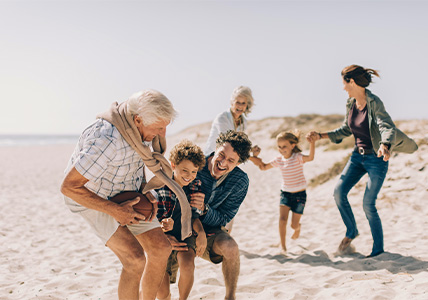 Família a jogar na praia que sabem a importância de preparar a sucessão com o BPI Valor Futuro.