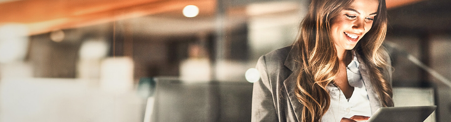 BPI Rendimento 5 anos - setembro 2030. Senhora de pé a pesquisar num tablet.