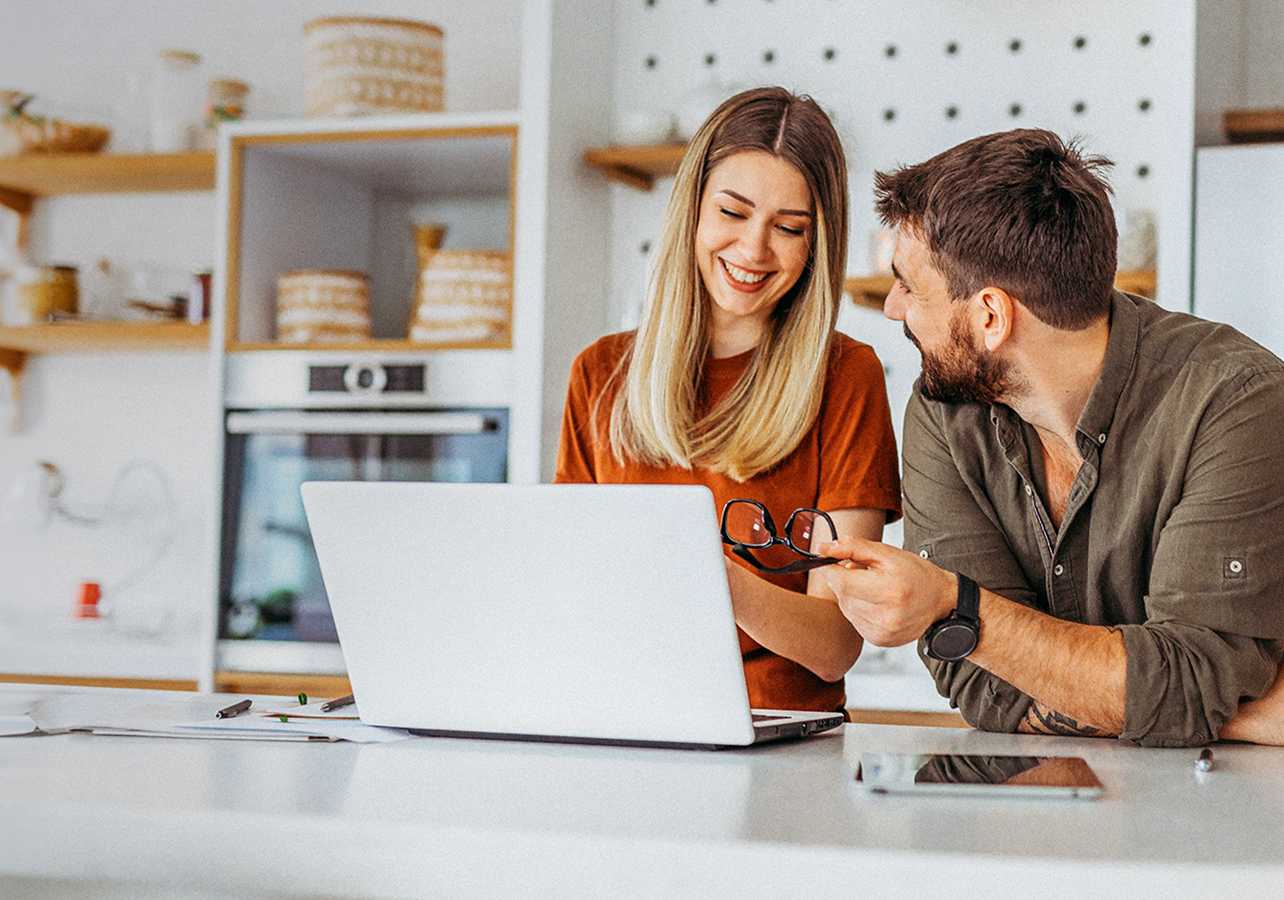 BPI Destino PPR 2060. Casal jovem sorridente a realizar uma simulação para a reforma num portátil.