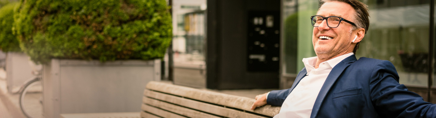 Homem de fato num banco de jardim. Representa o seguro BPI vida negócios.