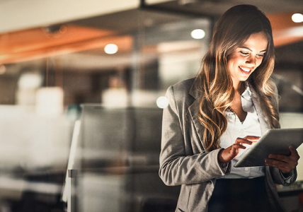 BPI Rendimento 5 anos - setembro 2030. Senhora de pé a pesquisar num tablet.